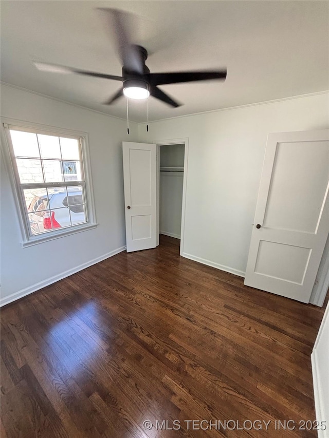 4607 E 4th Pl, Tulsa, OK 74112 - unfurnished bedroom with dark wood-style floors, baseboards, a ceiling fan, and a closet
