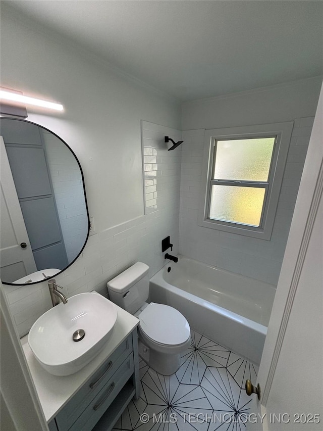 4607 E 4th Pl, Tulsa, OK 74112 - bathroom featuring toilet, vanity, tile walls, washtub / shower combination, and tile patterned floors