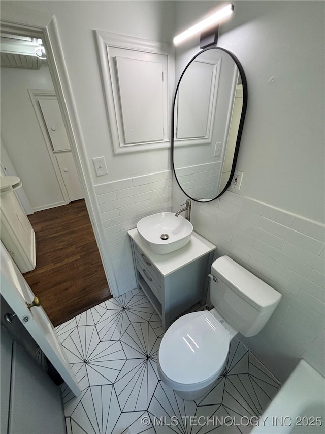 4607 E 4th Pl, Tulsa, OK 74112 - bathroom featuring vanity, tile walls, toilet, a wainscoted wall, and tile patterned flooring