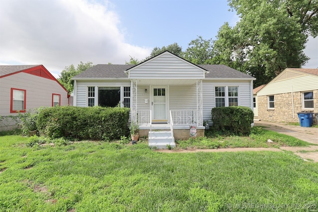 4607 E 4th Pl, Tulsa, OK 74112 - bungalow-style house with covered porch, a front lawn, and a shingled roof