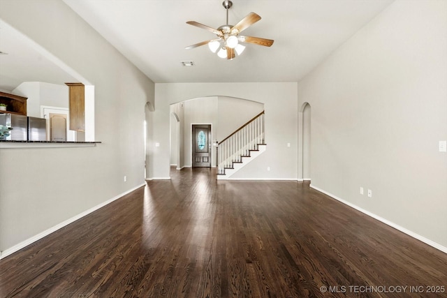 1620 E Granger St, Broken Arrow, OK 74012 - unfurnished living room featuring a ceiling fan, arched walkways, dark wood-style floors, and baseboards