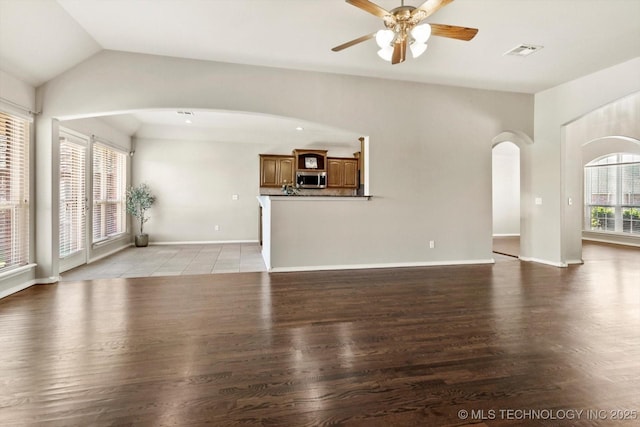 1620 E Granger St, Broken Arrow, OK 74012 - unfurnished living room with arched walkways, light wood-type flooring, a ceiling fan, vaulted ceiling, and baseboards