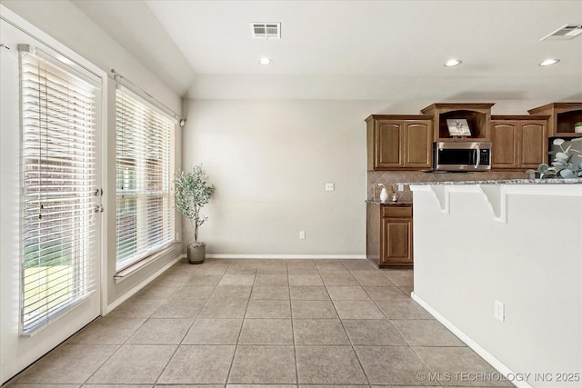 1620 E Granger St, Broken Arrow, OK 74012 - kitchen with stainless steel microwave, stone counters, tasteful backsplash, a breakfast bar, and open shelves
