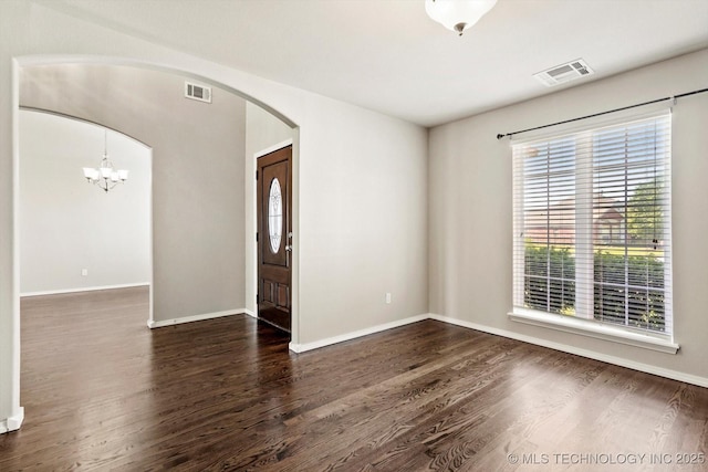 1620 E Granger St, Broken Arrow, OK 74012 - unfurnished room featuring arched walkways, dark wood-style floors, baseboards, and a chandelier