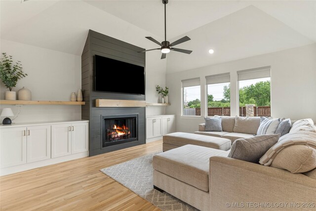 10215 E 121st Pl S, Bixby, OK 74008 - living room with a fireplace, light wood-style flooring, vaulted ceiling, a ceiling fan, and recessed lighting