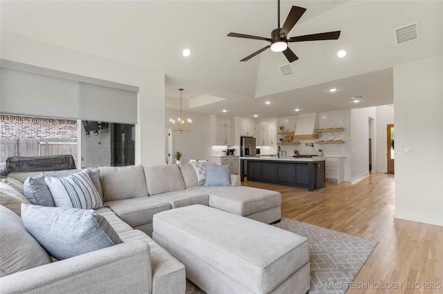 10215 E 121st Pl S, Bixby, OK 74008 - living room with ceiling fan, light wood-style flooring, a chandelier, high vaulted ceiling, and recessed lighting