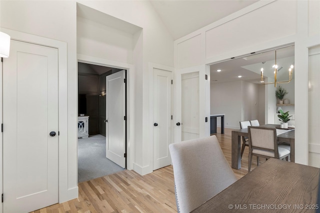 10215 E 121st Pl S, Bixby, OK 74008 - hallway with light wood-style floors, a chandelier, baseboards, and high vaulted ceiling