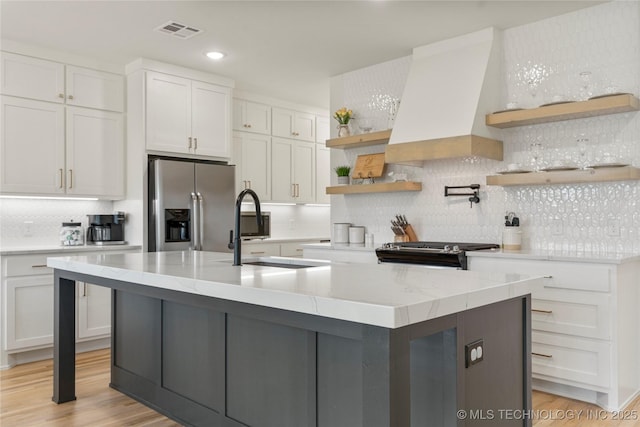 10215 E 121st Pl S, Bixby, OK 74008 - kitchen featuring stainless steel appliances, open shelves, premium range hood, white cabinets, and decorative backsplash