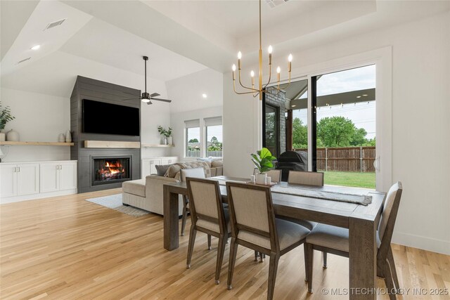 10215 E 121st Pl S, Bixby, OK 74008 - dining space with light wood-style flooring, a glass covered fireplace, ceiling fan, a chandelier, and recessed lighting