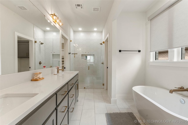 10215 E 121st Pl S, Bixby, OK 74008 - bathroom featuring a freestanding tub, a stall shower, tile patterned flooring, double vanity, and baseboards