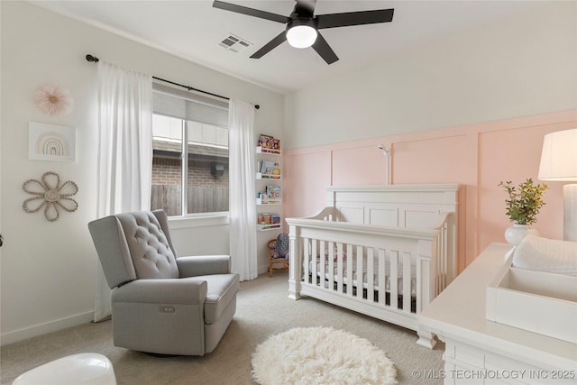 10215 E 121st Pl S, Bixby, OK 74008 - bedroom with a crib, light colored carpet, a ceiling fan, and a decorative wall