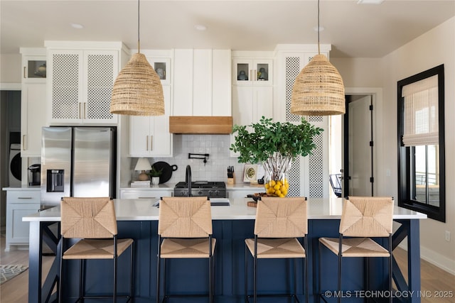 67 Lower Green Way Unit B, Carlton Landing, OK 74432 - kitchen with stainless steel refrigerator with ice dispenser, decorative backsplash, light countertops, white cabinetry, and a kitchen island with sink