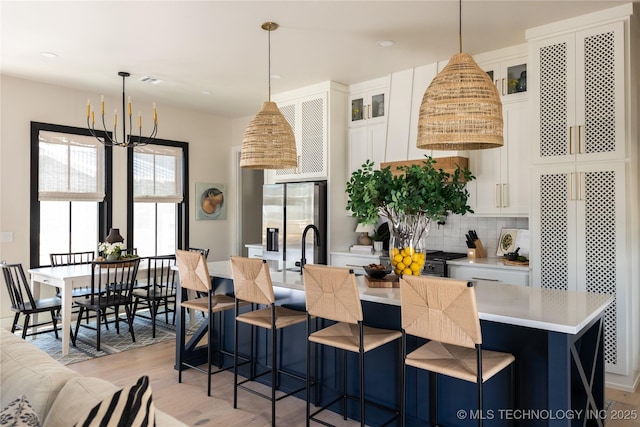 67 Lower Green Way Unit B, Carlton Landing, OK 74432 - kitchen featuring stainless steel fridge with ice dispenser, a center island with sink, light countertops, light wood-type flooring, and decorative backsplash