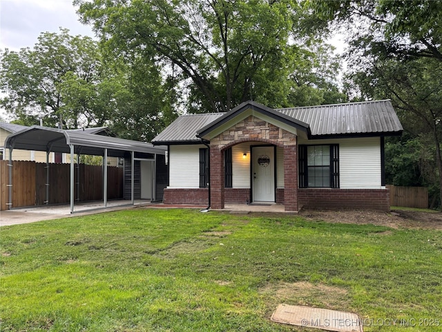 914 3rd Ave NE, Ardmore, OK 73401 - view of front of house featuring metal roof, a carport, and stone siding