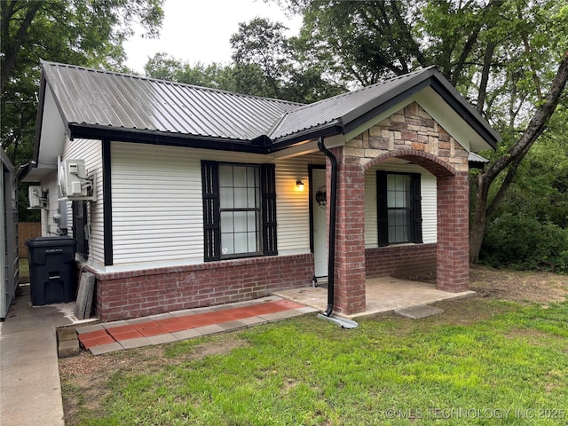 914 3rd Ave NE, Ardmore, OK 73401 - ranch-style house with a front lawn, brick siding, and metal roof