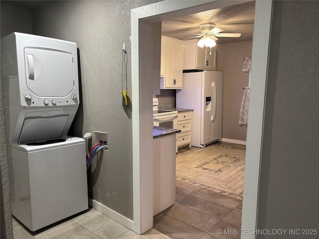 914 3rd Ave NE, Ardmore, OK 73401 - washroom with estacked washer and dryer, ceiling fan, a textured wall, and baseboards