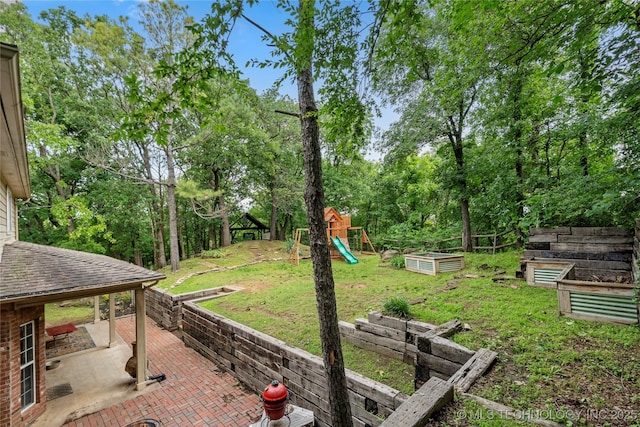 11937 S 18th St, Jenks, OK 74037 - view of green lawn featuring a garden, a playground, a patio area, and view of wooded area