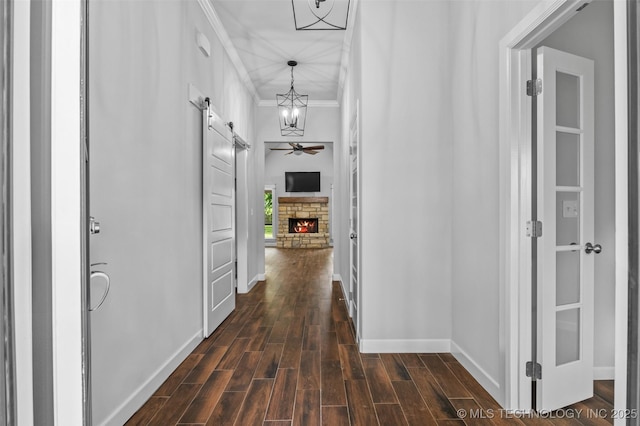 21893 S Arlene Dr, Claremore, OK 74019 - hallway with a barn door, ornamental molding, baseboards, dark wood-type flooring, and a chandelier