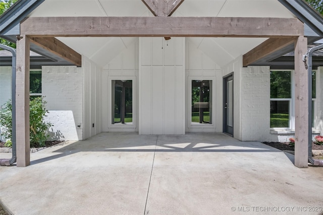 21893 S Arlene Dr, Claremore, OK 74019 - doorway to property featuring a patio area, board and batten siding, and brick siding