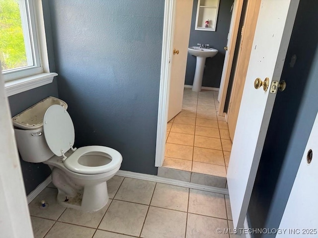 903 S Lynn Ln, Tulsa, OK 74108 - half bathroom featuring toilet, tile patterned floors, a sink, and baseboards