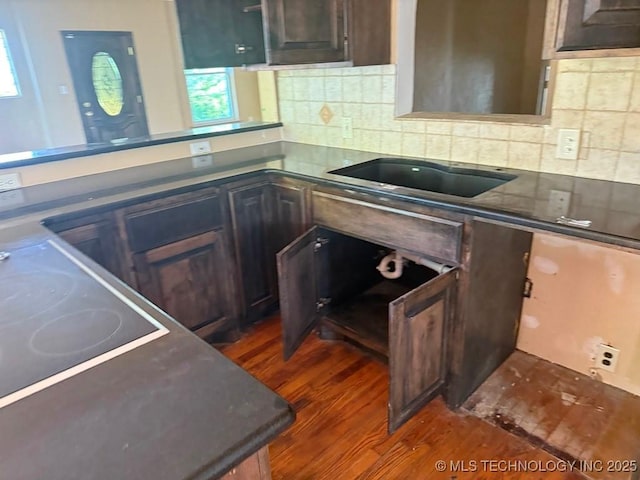 903 S Lynn Ln, Tulsa, OK 74108 - kitchen with dark wood-type flooring, backsplash, black electric stovetop, dark countertops, and a peninsula