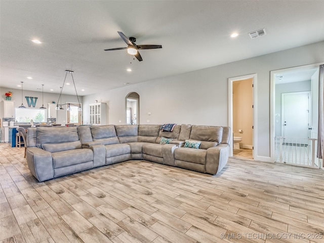 23814 E 91st St S, Broken Arrow, OK 74014 - living room featuring light wood-type flooring, arched walkways, a ceiling fan, recessed lighting, and baseboards