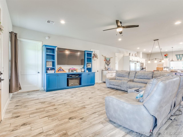 23814 E 91st St S, Broken Arrow, OK 74014 - living room featuring a ceiling fan, light wood finished floors, a glass covered fireplace, and recessed lighting