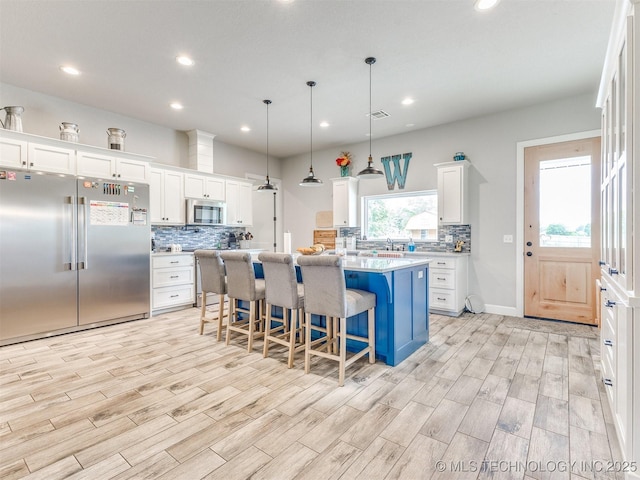 23814 E 91st St S, Broken Arrow, OK 74014 - kitchen featuring appliances with stainless steel finishes, tasteful backsplash, light wood-style flooring, light countertops, and white cabinetry