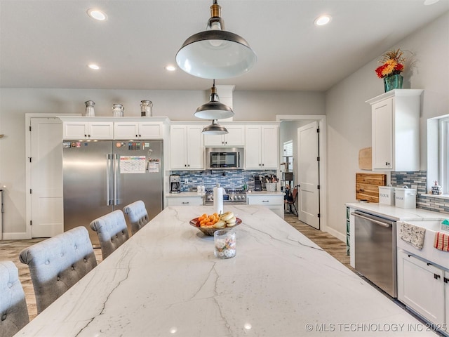 23814 E 91st St S, Broken Arrow, OK 74014 - kitchen with appliances with stainless steel finishes, white cabinetry, backsplash, hanging light fixtures, and recessed lighting