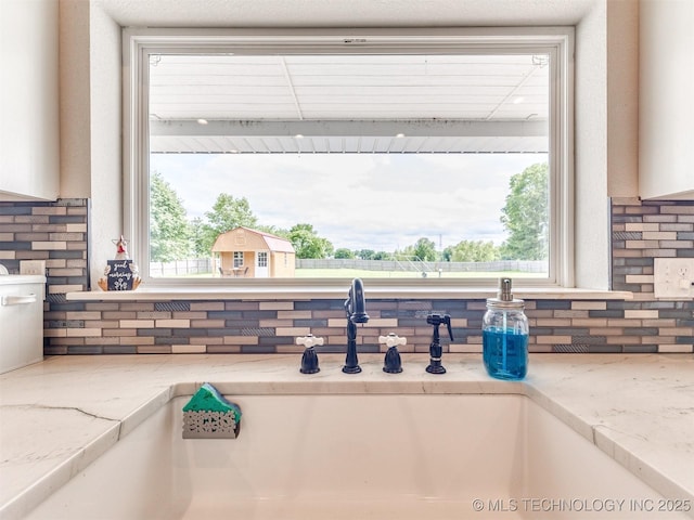23814 E 91st St S, Broken Arrow, OK 74014 - kitchen view of backsplash, a sink, and light stone counters