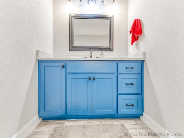 23814 E 91st St S, Broken Arrow, OK 74014 - bathroom with vanity, wood finished floors, baseboards, and a textured wall