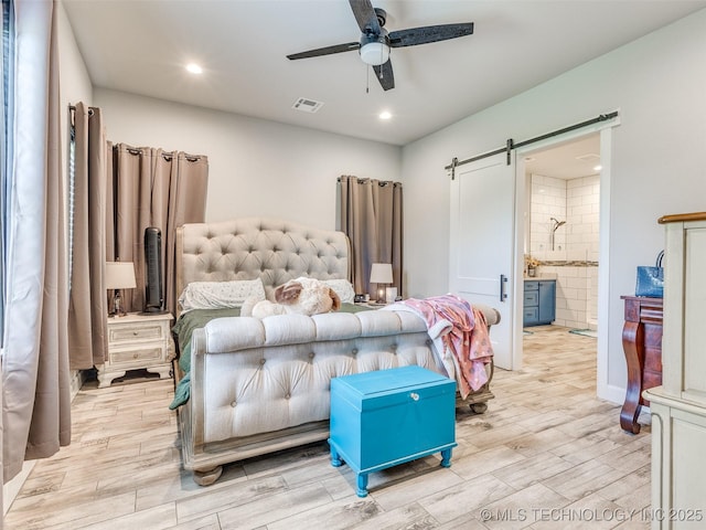 23814 E 91st St S, Broken Arrow, OK 74014 - bedroom with a barn door, light wood finished floors, recessed lighting, connected bathroom, and ceiling fan