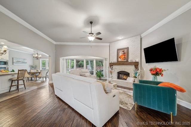 7734 S Indian Ave, Tulsa, OK 74132 - living room featuring a chandelier, a fireplace, crown molding, wood finished floors, and baseboards