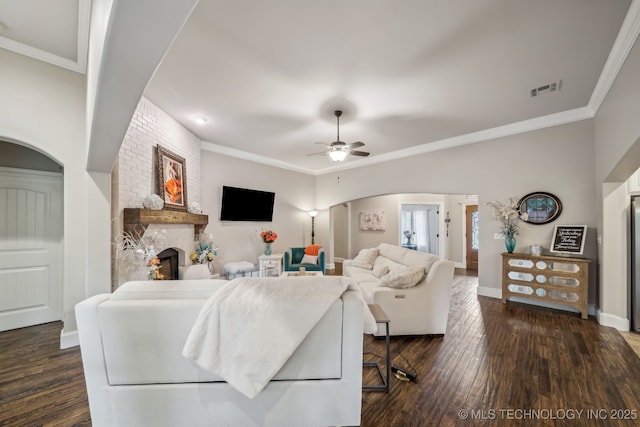 7734 S Indian Ave, Tulsa, OK 74132 - living room with a fireplace, arched walkways, ceiling fan, wood finished floors, and baseboards