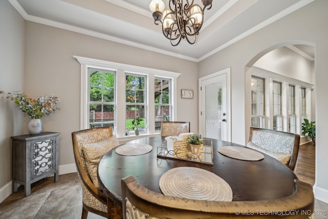 7734 S Indian Ave, Tulsa, OK 74132 - dining room featuring arched walkways, a chandelier, crown molding, and baseboards