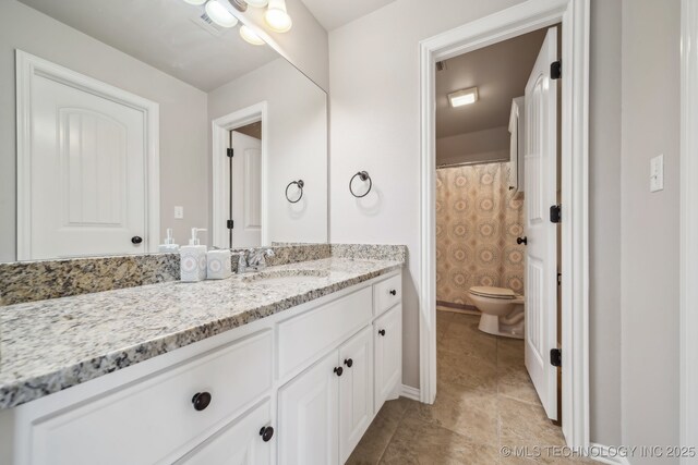 7734 S Indian Ave, Tulsa, OK 74132 - full bath featuring toilet, vanity, tile patterned floors, and baseboards