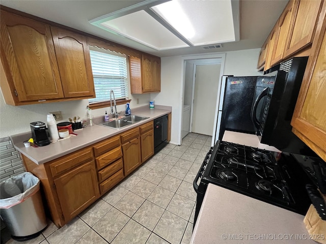 1700 S Cypress Ave, Broken Arrow, OK 74012 - kitchen with black appliances, light tile patterned floors, light countertops, and brown cabinets