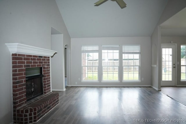 15310 E 89th Pl, Owasso, OK 74055 - unfurnished living room featuring ceiling fan, lofted ceiling, a brick fireplace, baseboards, and wood finished floors
