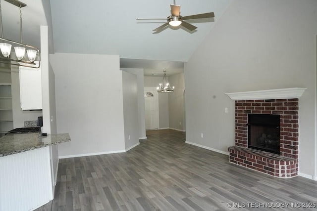 15310 E 89th Pl, Owasso, OK 74055 - unfurnished living room with a chandelier, high vaulted ceiling, wood finished floors, ceiling fan, and a fireplace