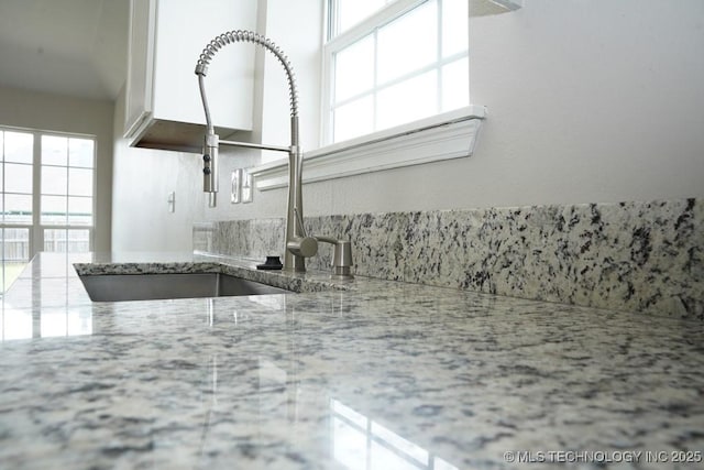 15310 E 89th Pl, Owasso, OK 74055 - kitchen view of a sink, light stone countertops, and white cabinetry