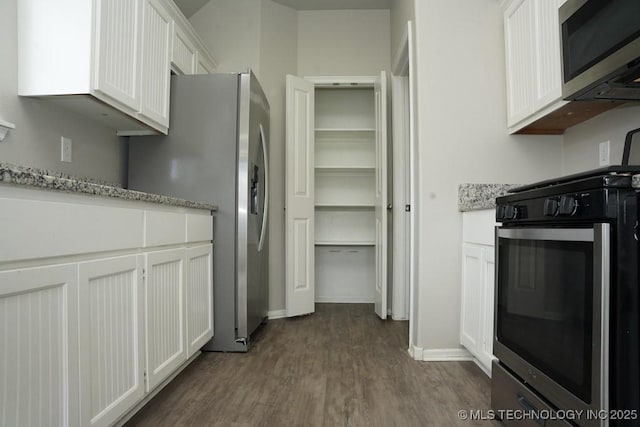 15310 E 89th Pl, Owasso, OK 74055 - kitchen with appliances with stainless steel finishes, white cabinets, dark wood-style flooring, baseboards, and light stone countertops