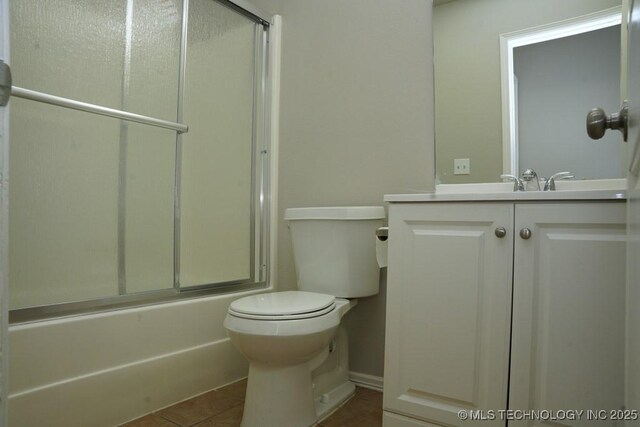 15310 E 89th Pl, Owasso, OK 74055 - full bathroom with tile patterned flooring, vanity, toilet, and bath / shower combo with glass door
