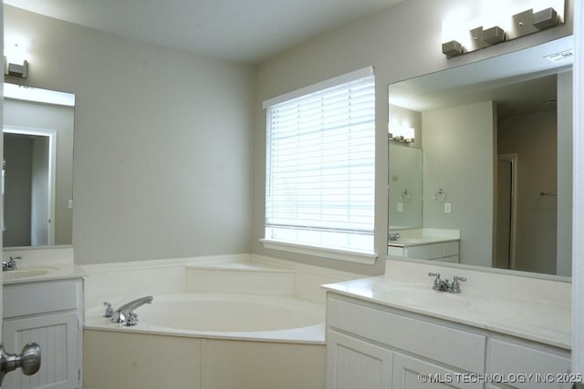 15310 E 89th Pl, Owasso, OK 74055 - bathroom with healthy amount of natural light, a bath, and two vanities