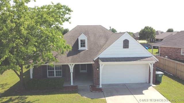 15310 E 89th Pl, Owasso, OK 74055 - view of front of home featuring covered porch, an attached garage, concrete driveway, a shingled roof, and brick siding