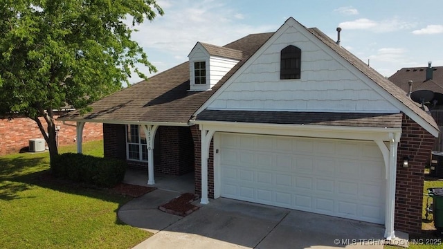 15310 E 89th Pl, Owasso, OK 74055 - view of front of property featuring an attached garage, a front yard, roof with shingles, brick siding, and driveway