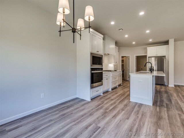 3011 S 6th Pl, Broken Arrow, OK 74012 - kitchen featuring stainless steel appliances, light wood-type flooring, baseboards, a chandelier, and light countertops