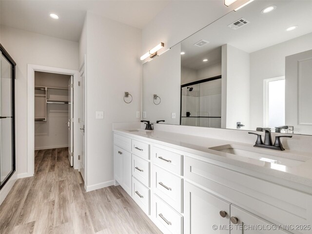 3011 S 6th Pl, Broken Arrow, OK 74012 - full bath featuring a shower stall, double vanity, a spacious closet, wood finished floors, and baseboards
