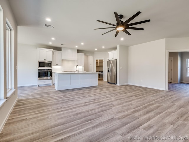 3011 S 6th Pl, Broken Arrow, OK 74012 - unfurnished living room with ceiling fan, baseboards, recessed lighting, light wood-type flooring, and a sink