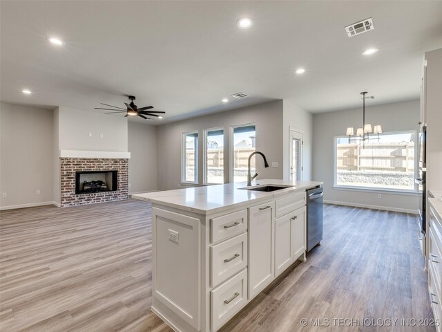 3011 S 6th Pl, Broken Arrow, OK 74012 - kitchen featuring a sink, dishwasher, ceiling fan, white cabinetry, and light wood-type flooring