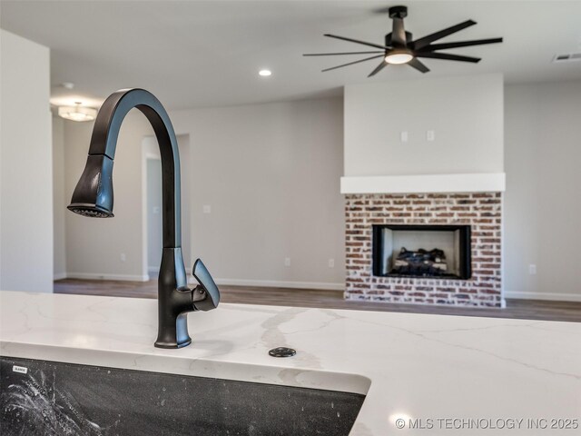 3011 S 6th Pl, Broken Arrow, OK 74012 - unfurnished living room featuring a sink, wood finished floors, ceiling fan, recessed lighting, and a fireplace
